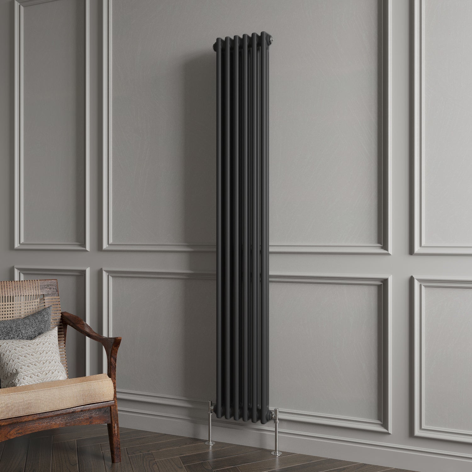 Black vertical radiator against a gray paneled wall with a wooden chair.