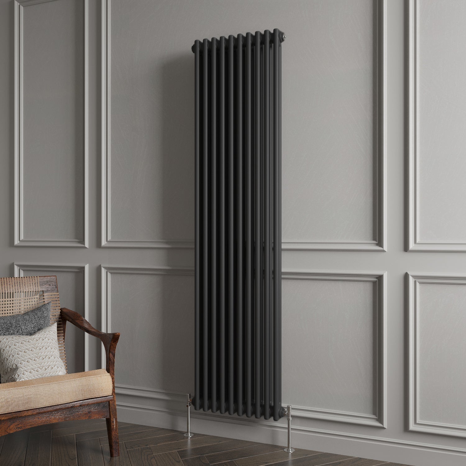 Black vertical radiator against a gray paneled wall with a wooden chair.