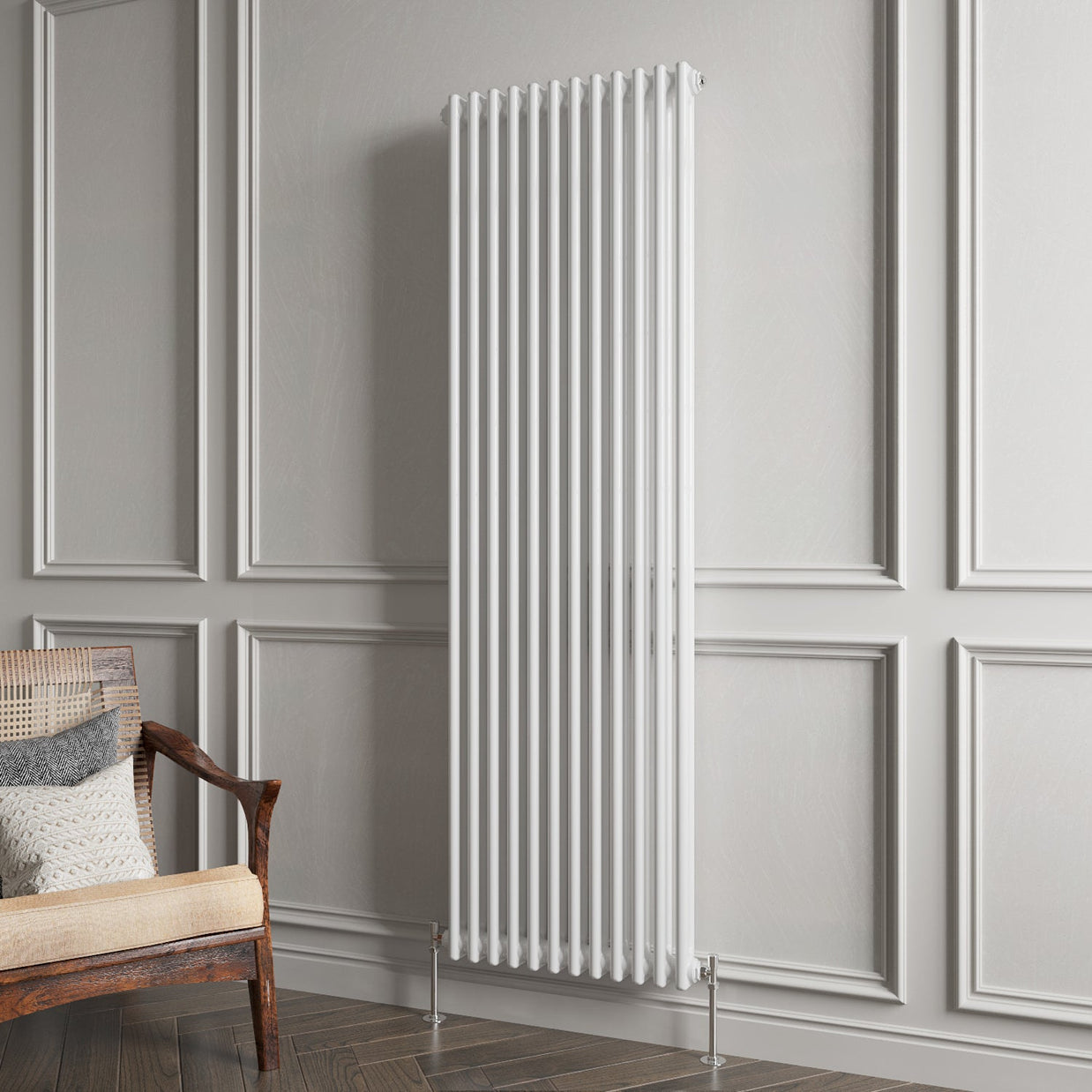 White vertical radiator on a gray paneled wall with a wooden chair and cushions.