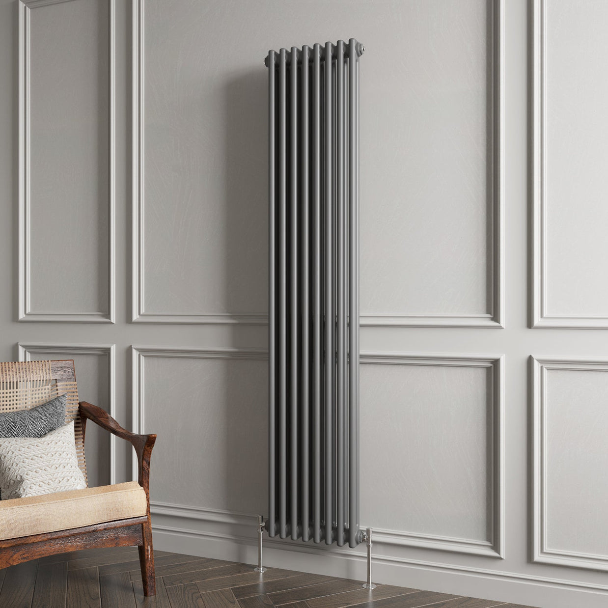 Vertical radiator against a gray paneled wall with a wooden chair.