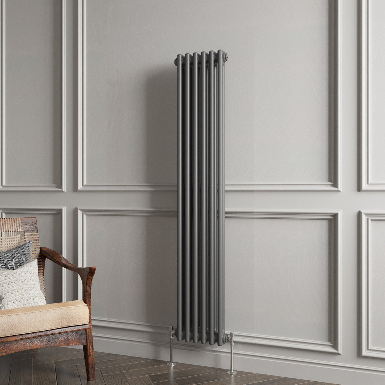 Vertical radiator against a gray paneled wall with a wooden chair.
