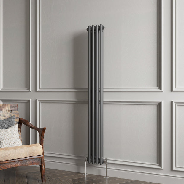 Vertical radiator against a gray paneled wall with a wooden chair.
