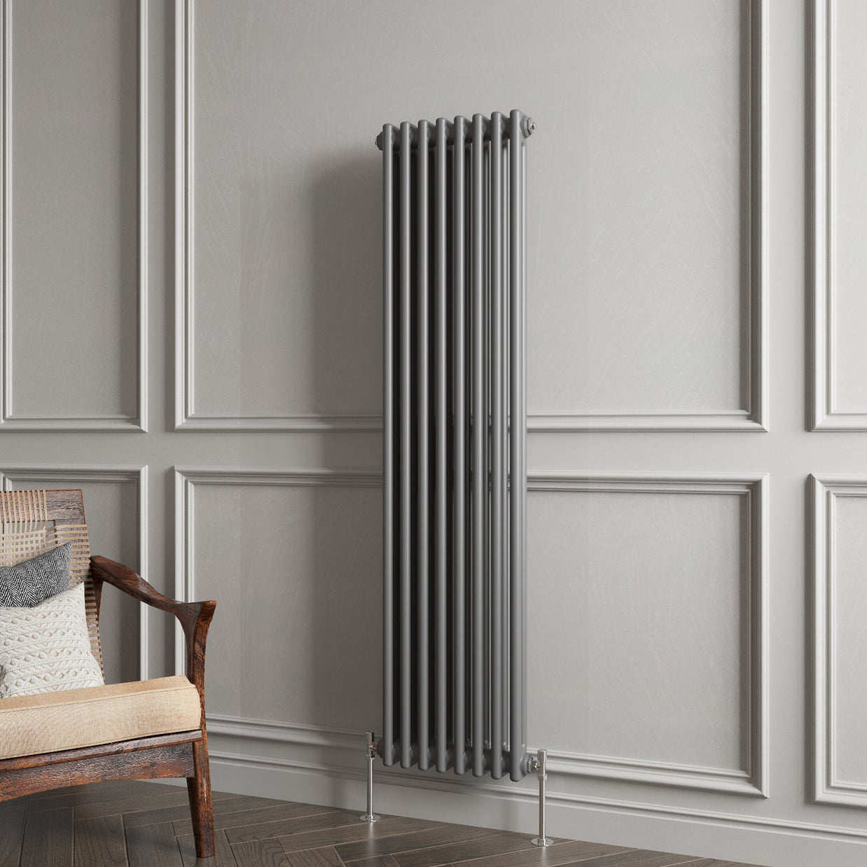 Vertical radiator against a gray paneled wall with a wooden chair.