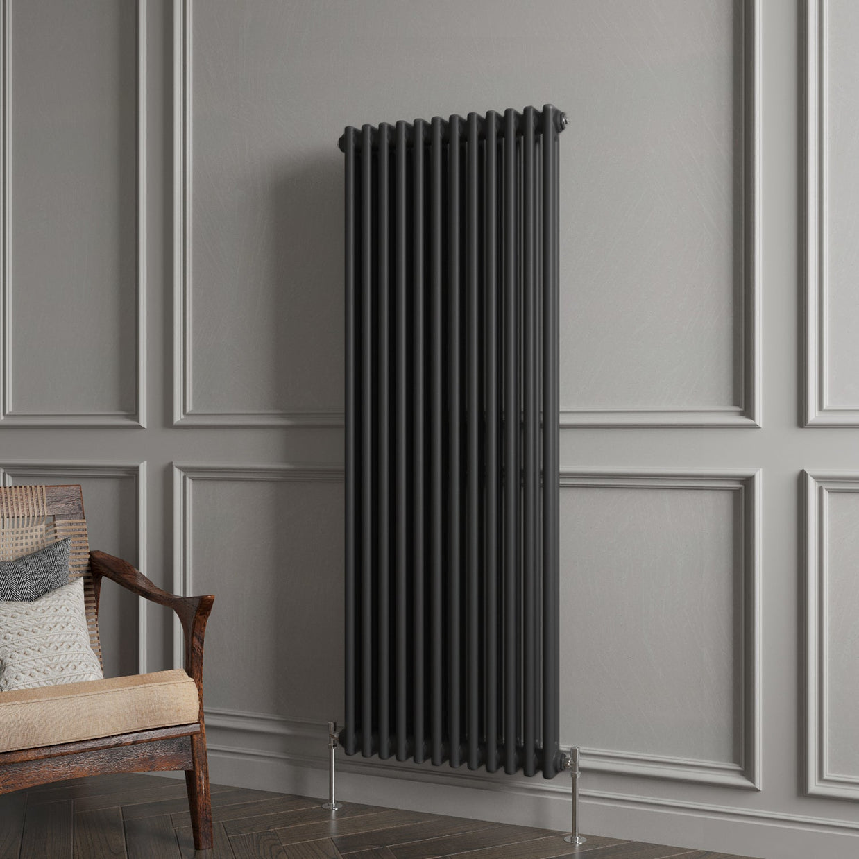 Black radiator against a gray paneled wall with a wooden chair.