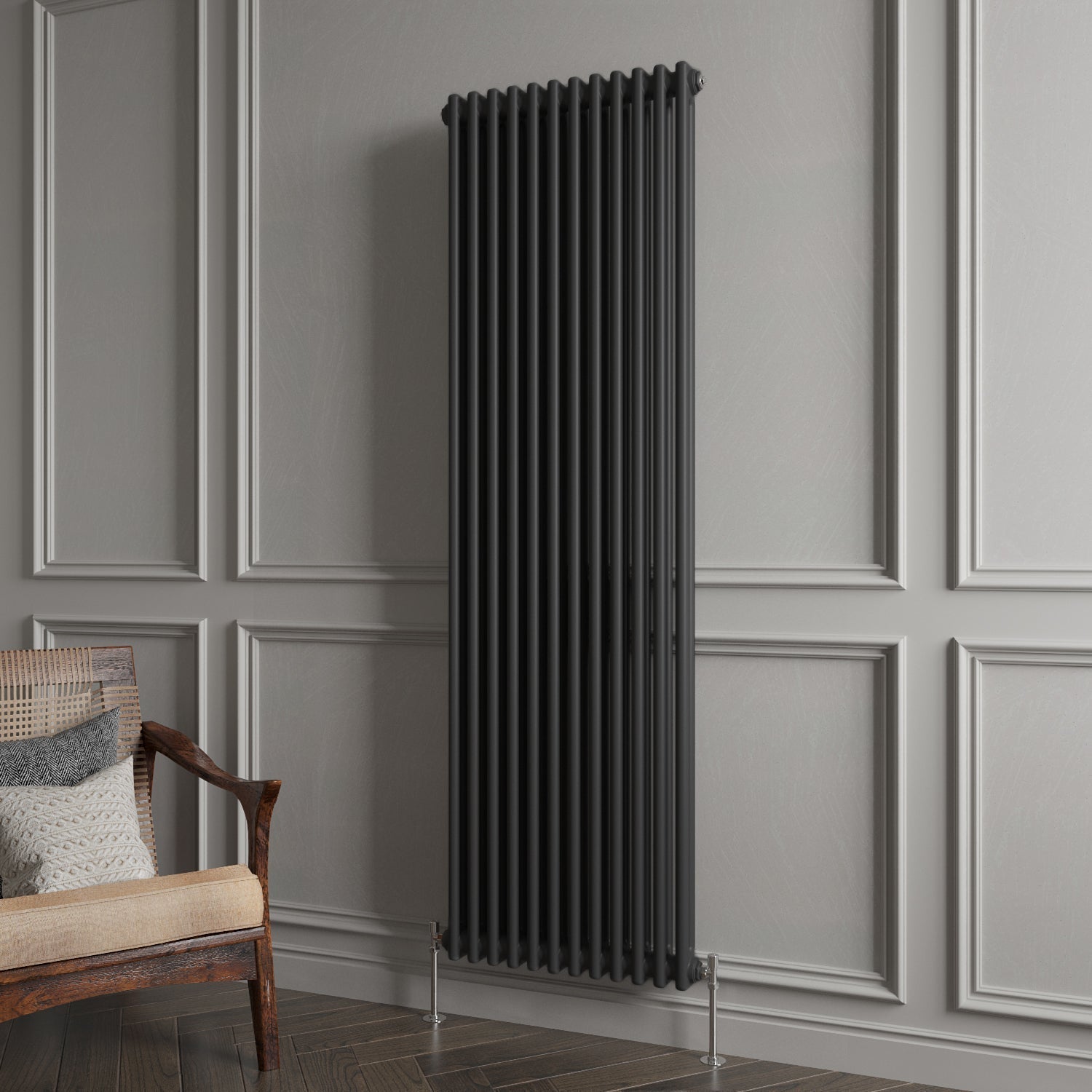 Black vertical radiator against a gray paneled wall with a wooden chair.
