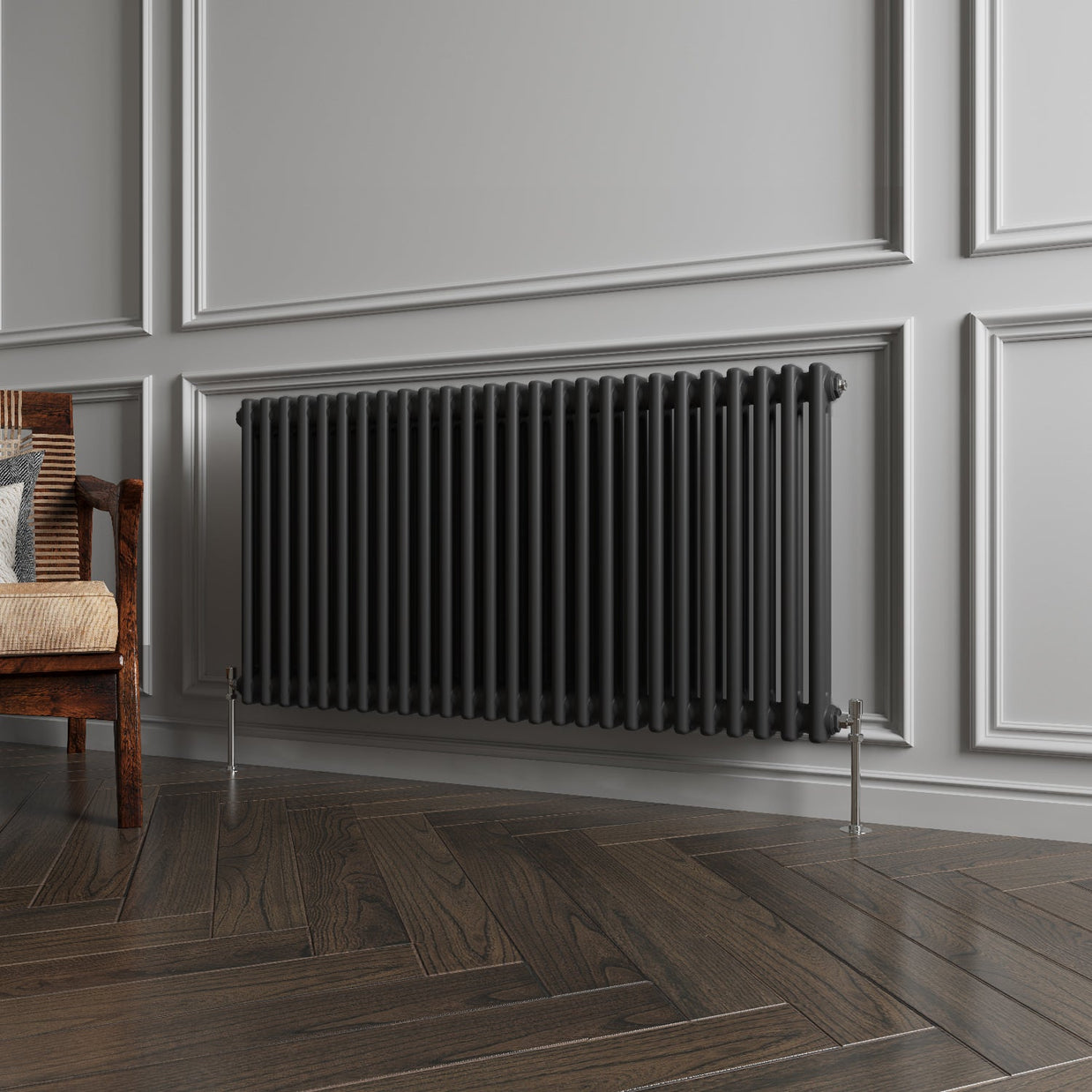 Black radiator on a gray paneled wall with wooden flooring