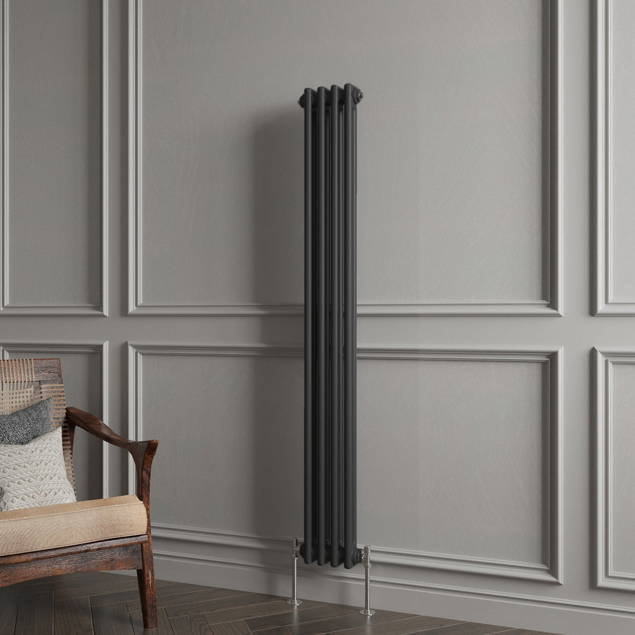Tall black radiator against a gray paneled wall with a wooden chair.