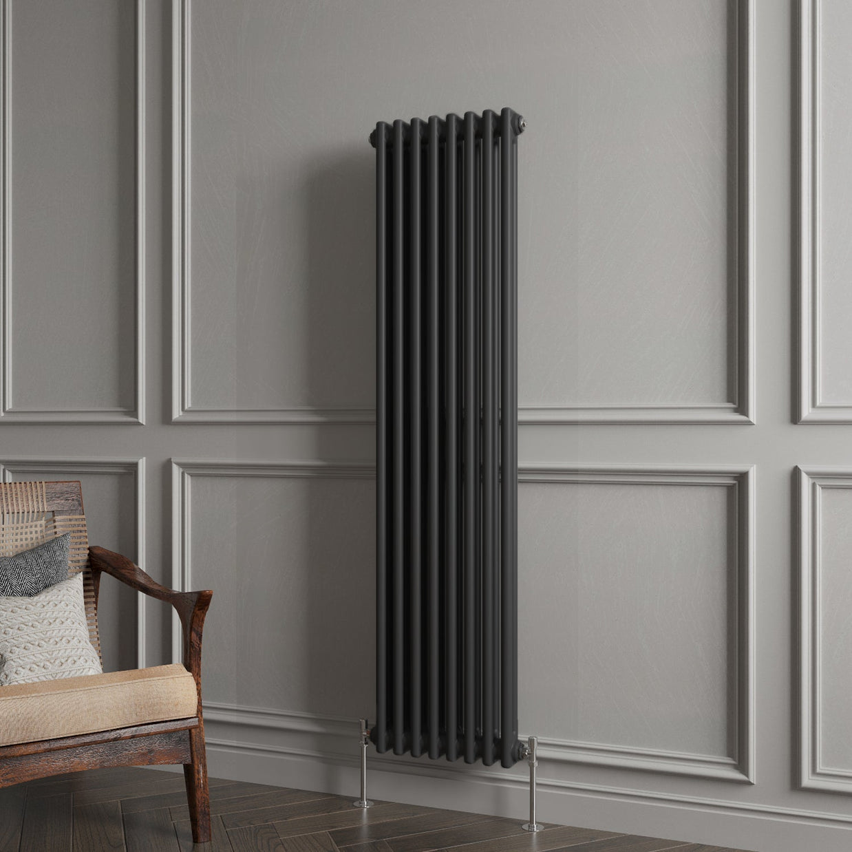 Black radiator against a gray paneled wall with a wooden chair.
