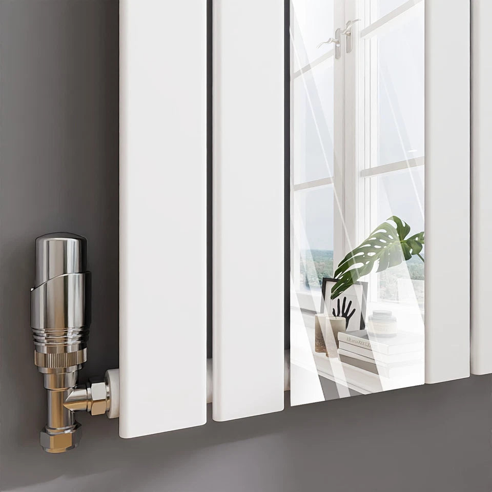 Modern radiator with a silver valve on a gray wall with a window in the background